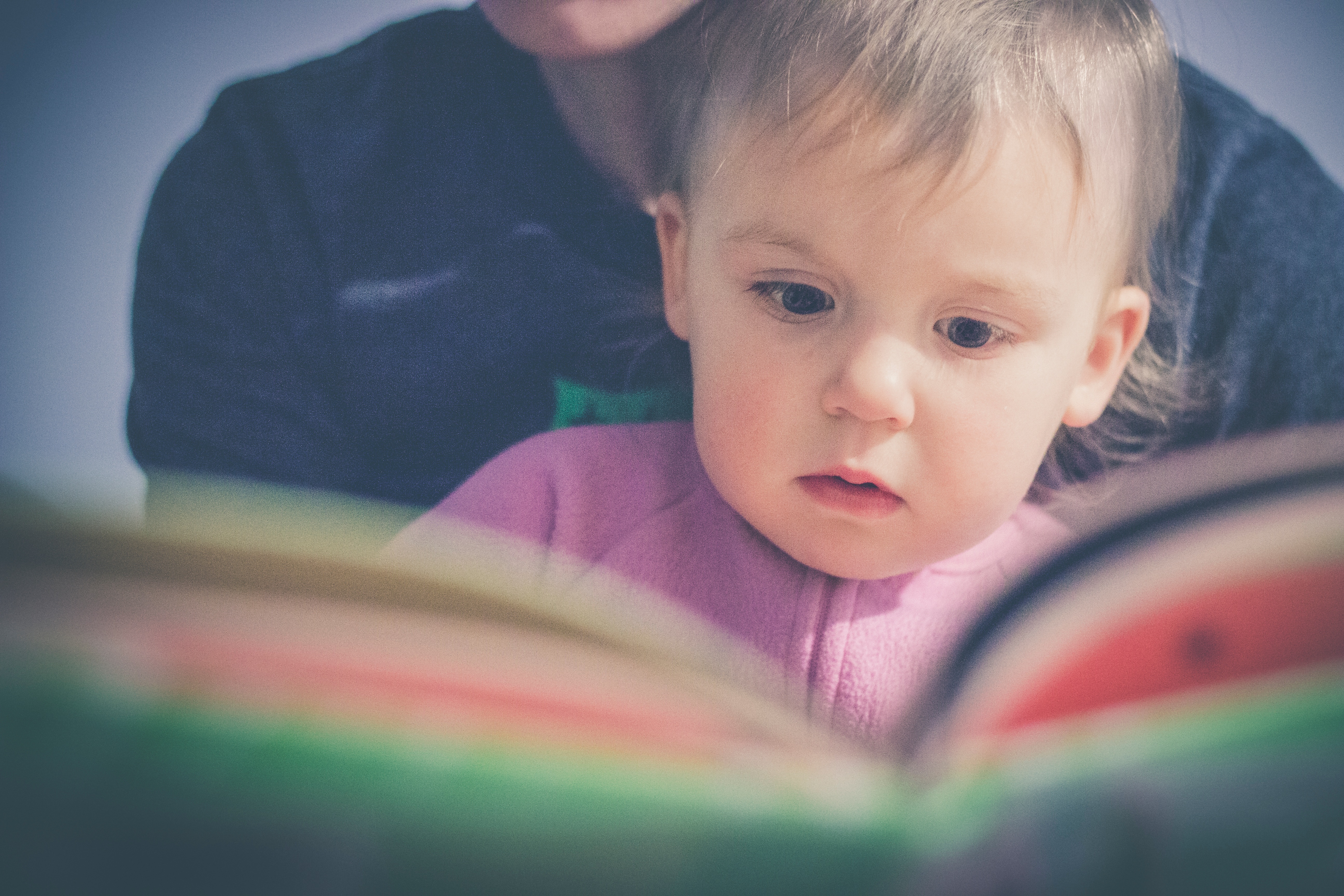 Toddler reading with adult